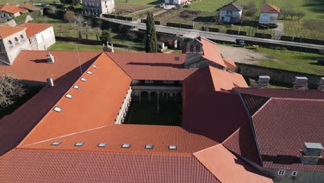 Drone-orbits-around-courtyard-caught-in-shadows-of-buildings,-San-Salvador-de-Ferreira