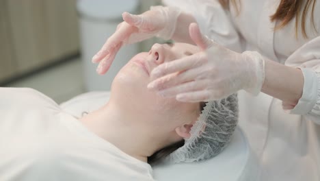 cosmetologist cleansing face for procedure