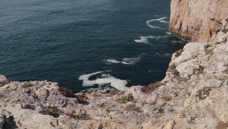 Stunning-shot-of-Algarve-coast-from-cliff-onto-the-blue-ocean-in-evening-sunlight