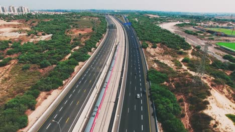 Ein-Zug-Fährt-In-Der-Nähe-Der-Autobahn-In-Die-Stadt