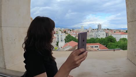 Schöne-Frau,-Die-Beim-Vlogging-Ihr-Smartphone-In-Der-Hand-Hält-Und-Auf-Verschüttete-Ausblicke-Blickt,-Kroatien
