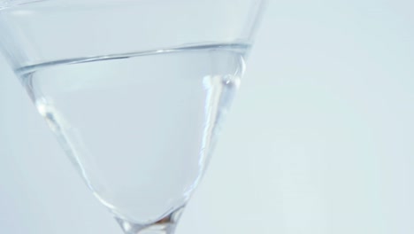 olive stick falling in the cocktail glass