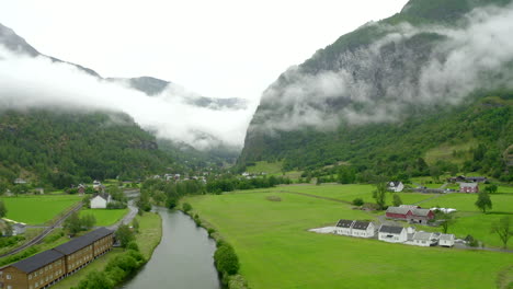 establishing shoot of drone flying in norway - aurlandsfjord- flam slowly gaining altitude and flying towards a valley