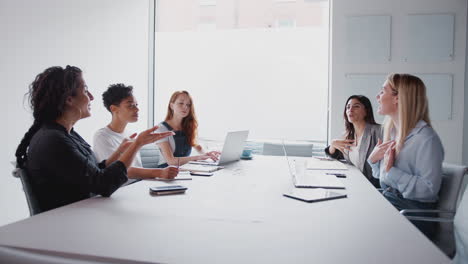 Ein-Team-Junger-Geschäftsfrauen-Mit-Laptops-Und-Tablets-Trifft-Sich-Am-Tisch-In-Einem-Modernen-Arbeitsbereich