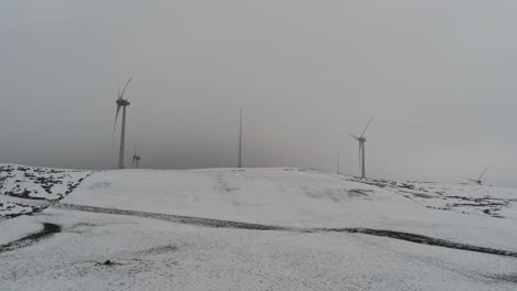 Campo-De-Montaña-De-Invierno-Turbinas-De-Viento-En-Las-Tierras-Altas-Rurales-Vista-Aérea-Frío-Ventisquero-Valle-Ladera-Empujar-Hacia-Adentro