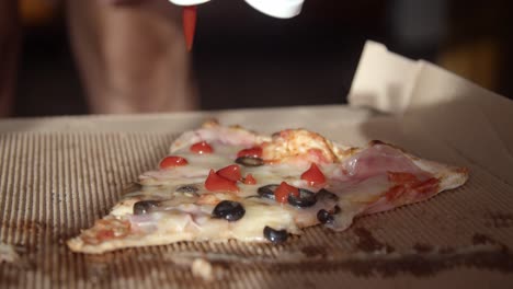 verter ketchup en una rebanada de pizza en una caja de cartón, cerrar, cámara lenta