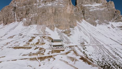 Tilt-and-fly-away-movement-to-show-the-wonderful-Rifugio-Auronzo-at-the-foot-of-the-Tre-Cime-of-Lavaredo