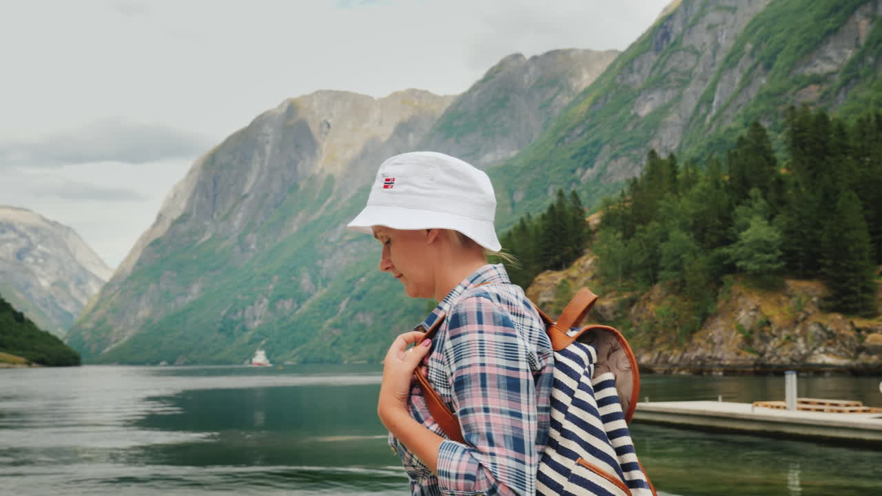 женщина с рбчаком гуляет на фоне красивого пейзажа в норвегии - красивый фьорд