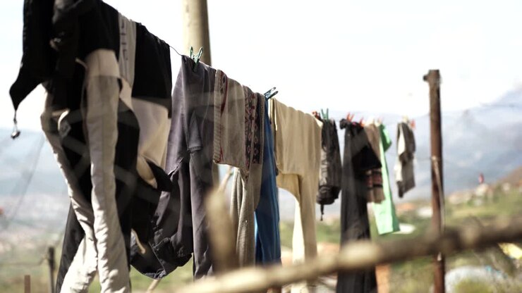 Clean washed clothes hanged on wire, blurred nature background in village