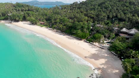 an overhead, slow reveal drone shot of pansea beach on the west coast of phuket island in the south of thailand