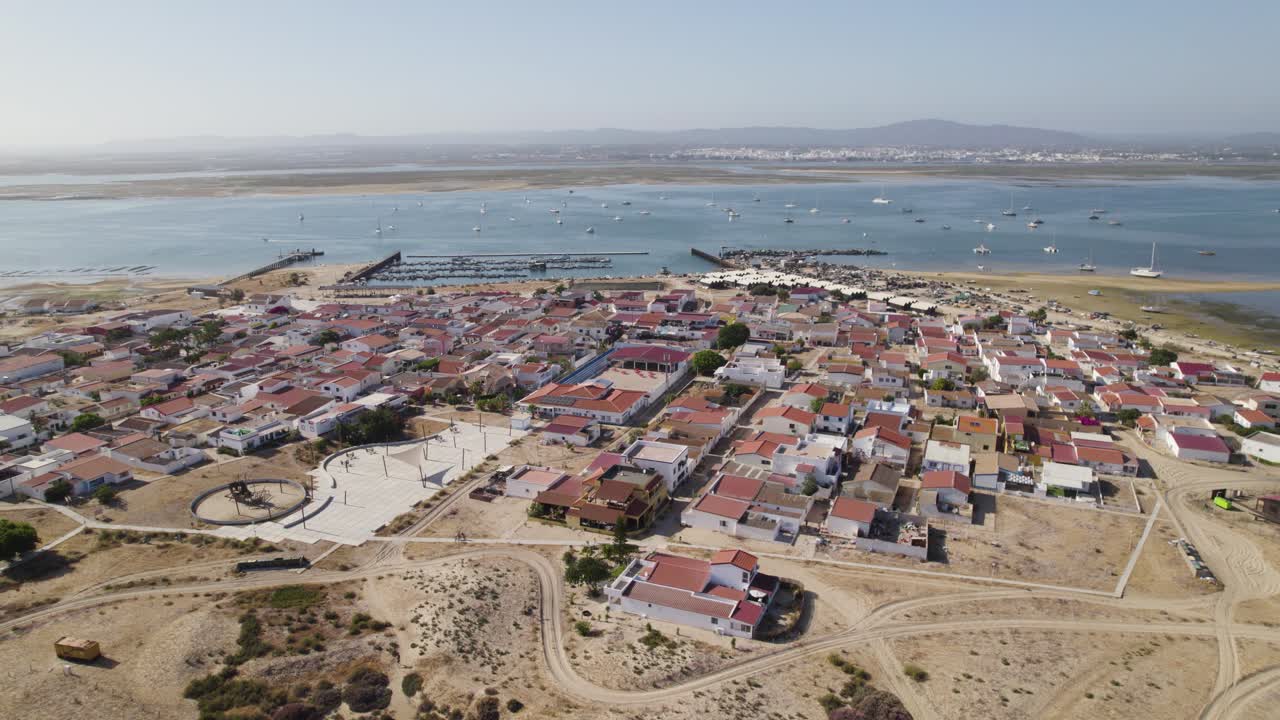 orbita panorámica sobre la isla de culatra, portugal, con vistas a los barcos y el puerto.