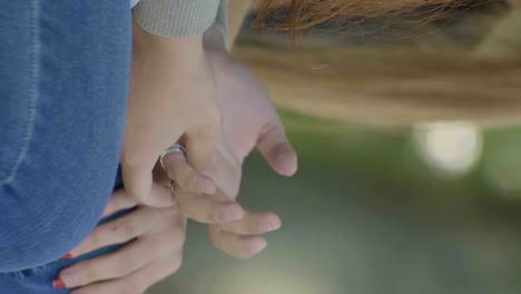 Hands-of-young-blonde-female-showing-stress-and-worry-while-sitting,-vertical-view