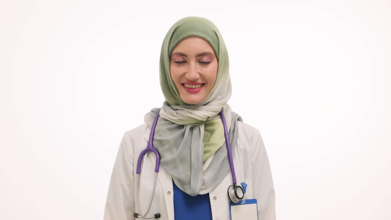 A smiling female doctor in a hijab with a stethoscope
