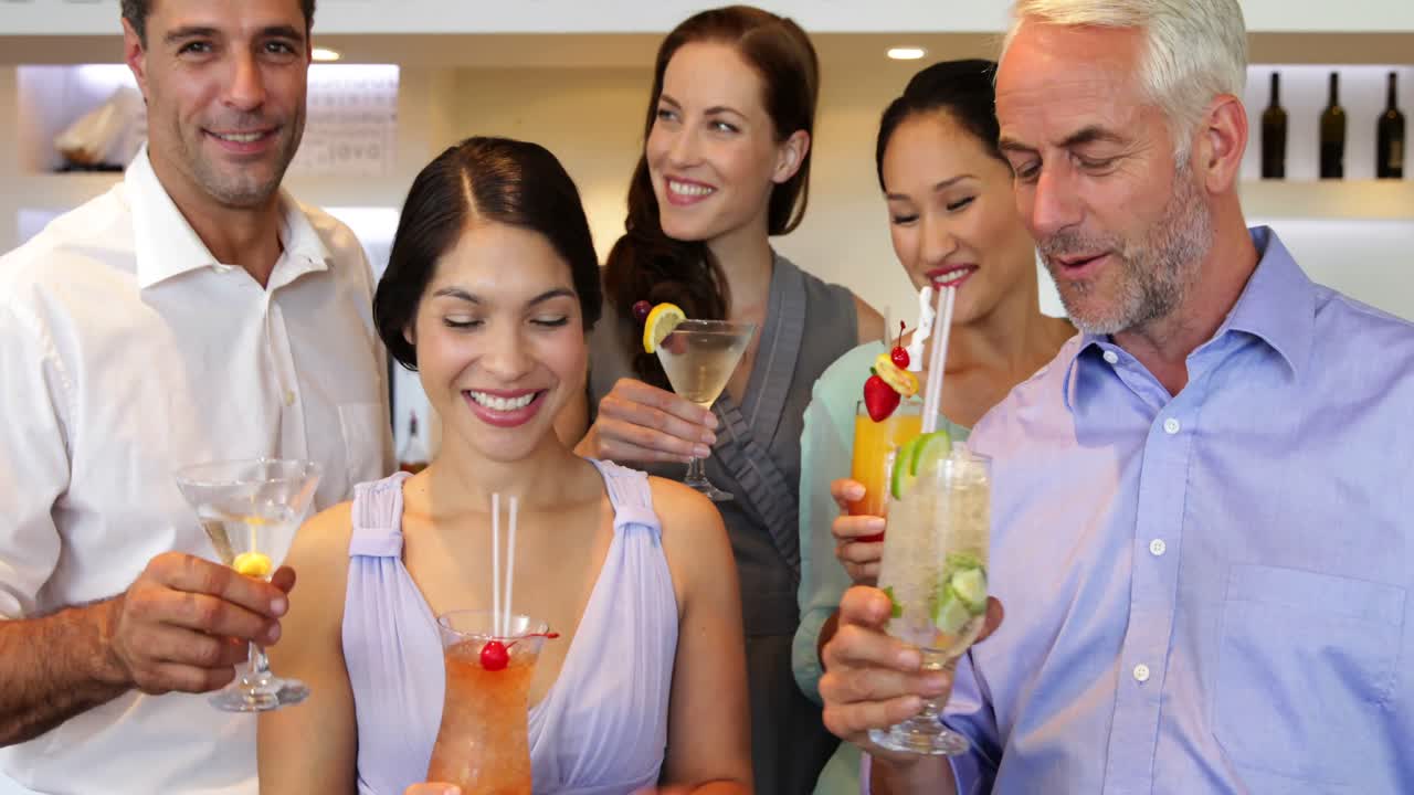 amigos atractivos brindando a la cámara con cócteles