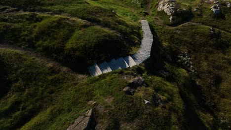 squish studio with tilt up reveal from an aerial drone over the scenic landscape viewing the isolated modern design artistic structure by todd saunders on fogo island, canada