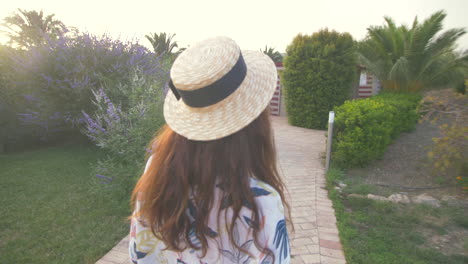 woman walks through a beautiful garden path in a summer resort