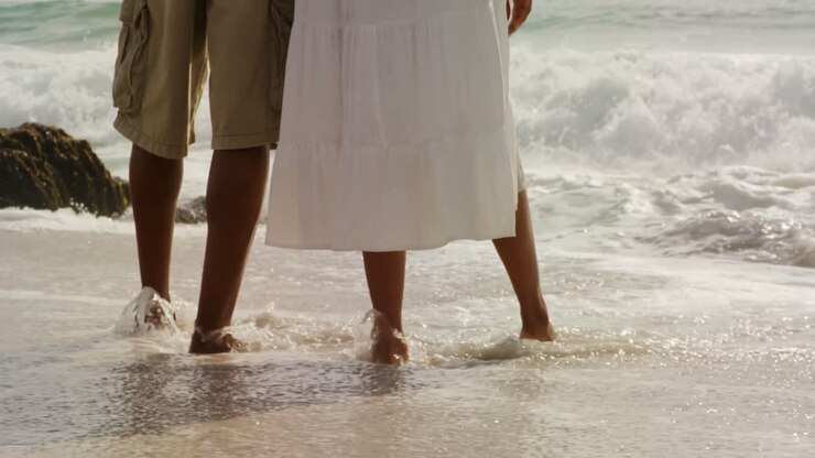 Gambe di coppia afroamericana in piedi insieme sulla spiaggia 4k