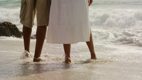 Low-section-of-African-american-couple-standing-together-on-the-beach-4k-