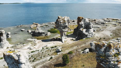 Flying-over-tall-limestone-sea-stacks-or-rauks,-Gotland-Island,-Sweden