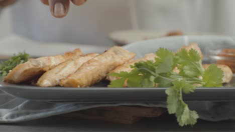 close up of chef's hand tucking stuffing on hotdog. chef's activities at work. breakfast or lunch concept