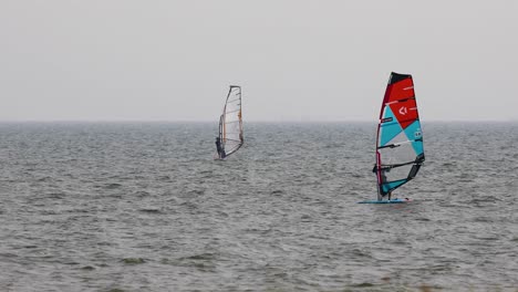 wind surfing off the coast of pattaya in thailand on an overcast day. extreme recreational sport activity