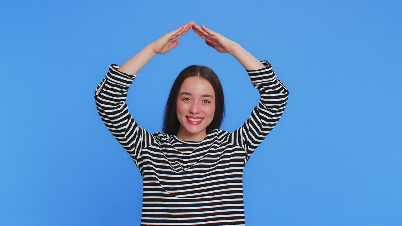 Woman feeling in safe making roof above head with hands insurance security service playing game