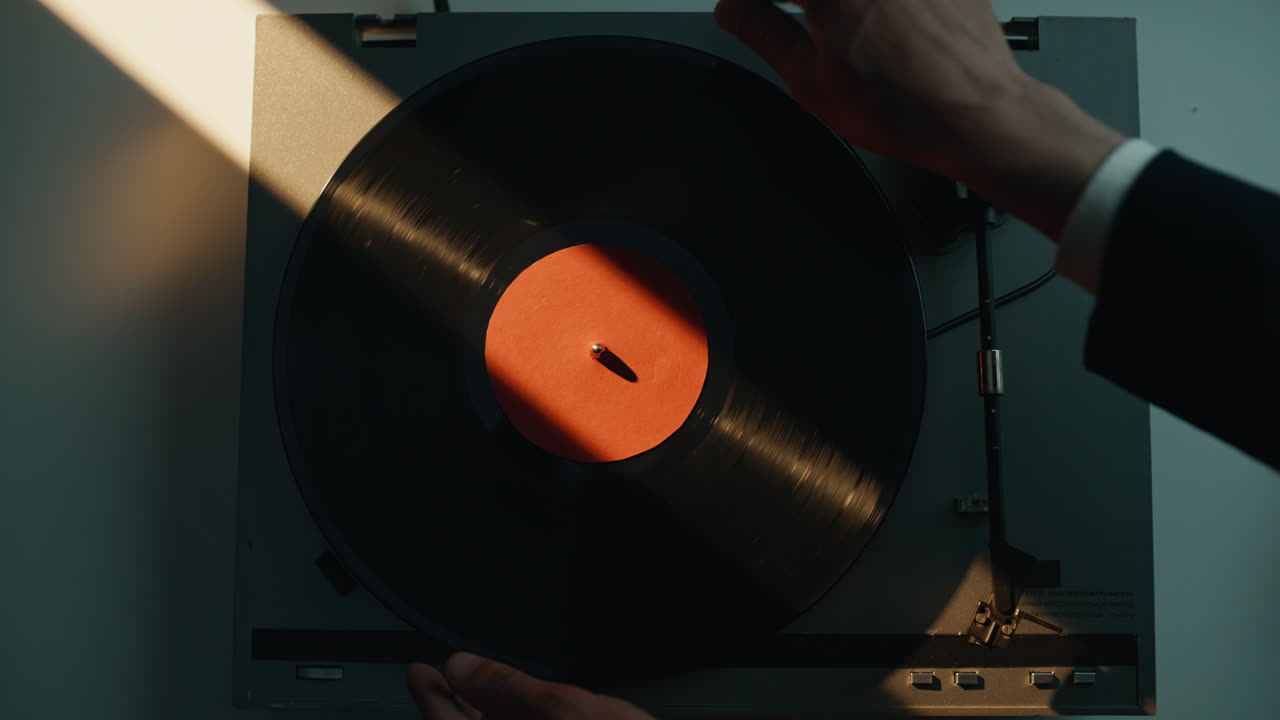 Man taking vinyl disc from gramophone at home closeup. Hand turning off play