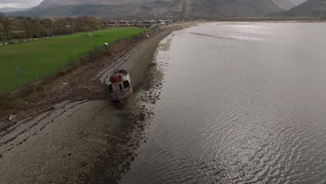 Establishing-shot-of-Corpach-Shipwreck-and-revealing-a-snowy-Ben-Nevis-behind