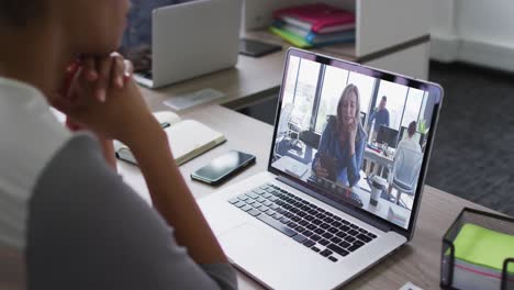 Afroamerikanische-Geschäftsfrau,-Die-Mit-Einem-Laptop-Am-Schreibtisch-Sitzt-Und-Einen-Videoanruf-Mit-Einer-Kollegin-Führt