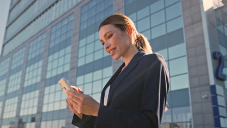 business lady reading sms on telephone outdoors after office work day close up.