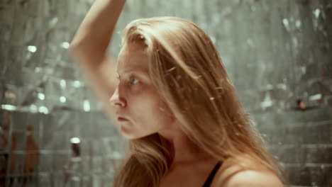 woman performing expressive dance movements against silver background