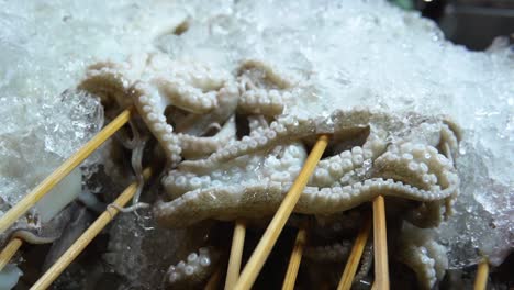 pulpo crudo en palos para asar a la parrilla