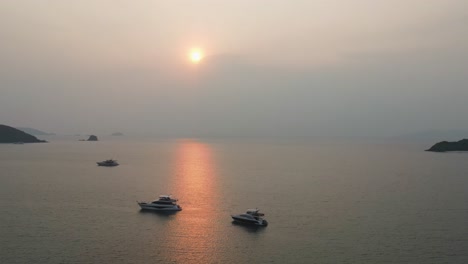 Luftaufnahme-Von-Yachten,-Die-In-Den-Gewässern-Vor-Dem-Strand-Von-Ao-Suan-Yai-Vor-Anker-Liegen,-Mit-Goldorangefarbenem-Sonnenuntergang-über-Dem-Horizont