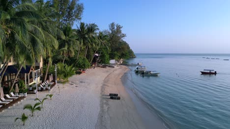 Wake-up-to-gentle-waves,-golden-light,-and-palm-trees-swaying-on-a-tropical-beach