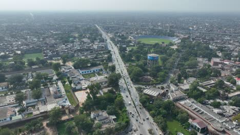 Toma-Aérea-De-La-Ciudad-De-Gujranwala-Con-Edificios,-Industrias,-Estadio-De-Cricket-Y-Mucha-Vegetación-En-Punjab,-Pakistán.