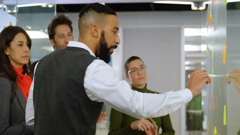 executives discussing over sticky notes on glass wall 4k