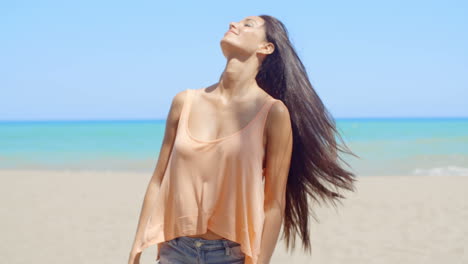 Frau-Am-Strand-Mit-Im-Wind-Wehenden-Haaren