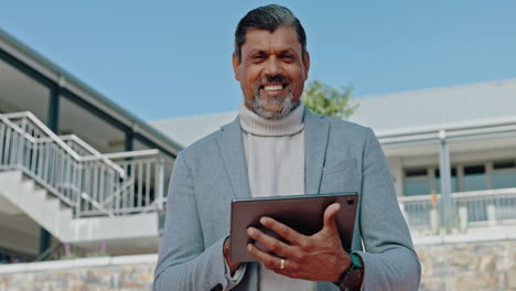 hombre de negocios sonriente sosteniendo una tableta fuera del edificio