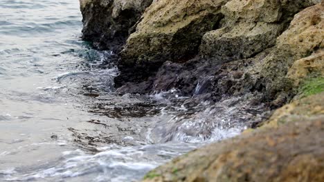 Olas-Tranquilas-Golpeando-Rocas-En-Un-Día-Sombrío