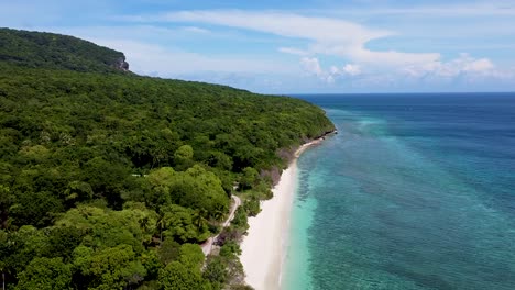aerial drone rising over pristine white sandy beach, crystal clear ocean water and forest trees on tropical island of timor-leste, southeast asia