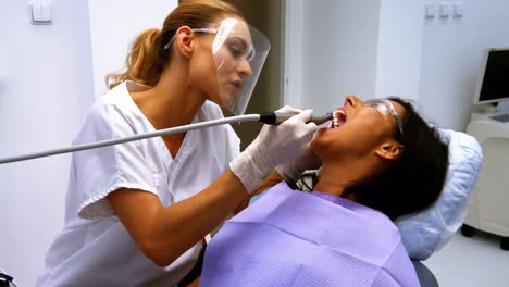 dentista examinando a una paciente femenina con herramientas