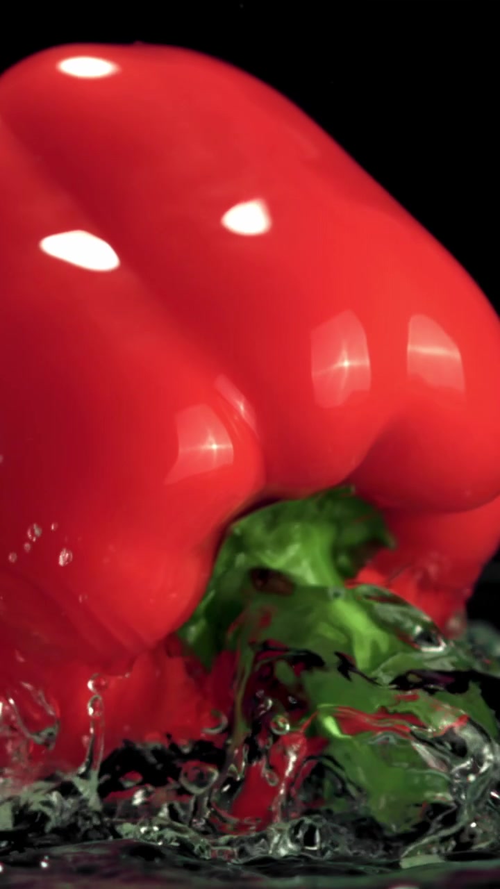 Pimentão Vermelho em Câmera Lenta Emergindo da Água com Respingos