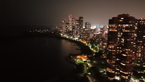 high-rise skyline at night in stonegate-queensway neighbourhood by lake ontario in toronto, ontario, canada. - aerial shot