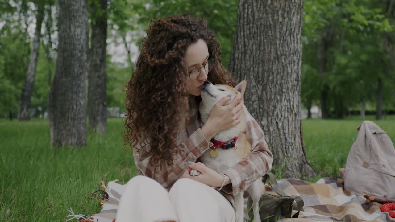 Woman kissing her Shiba Inu dog in a park
