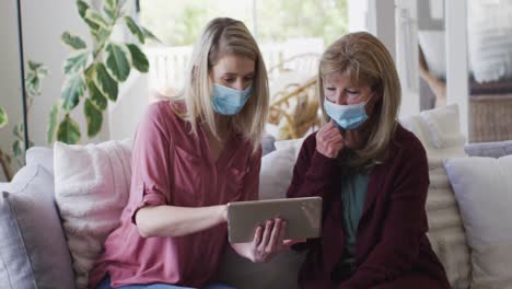 mother and daughter using digital tablet at home