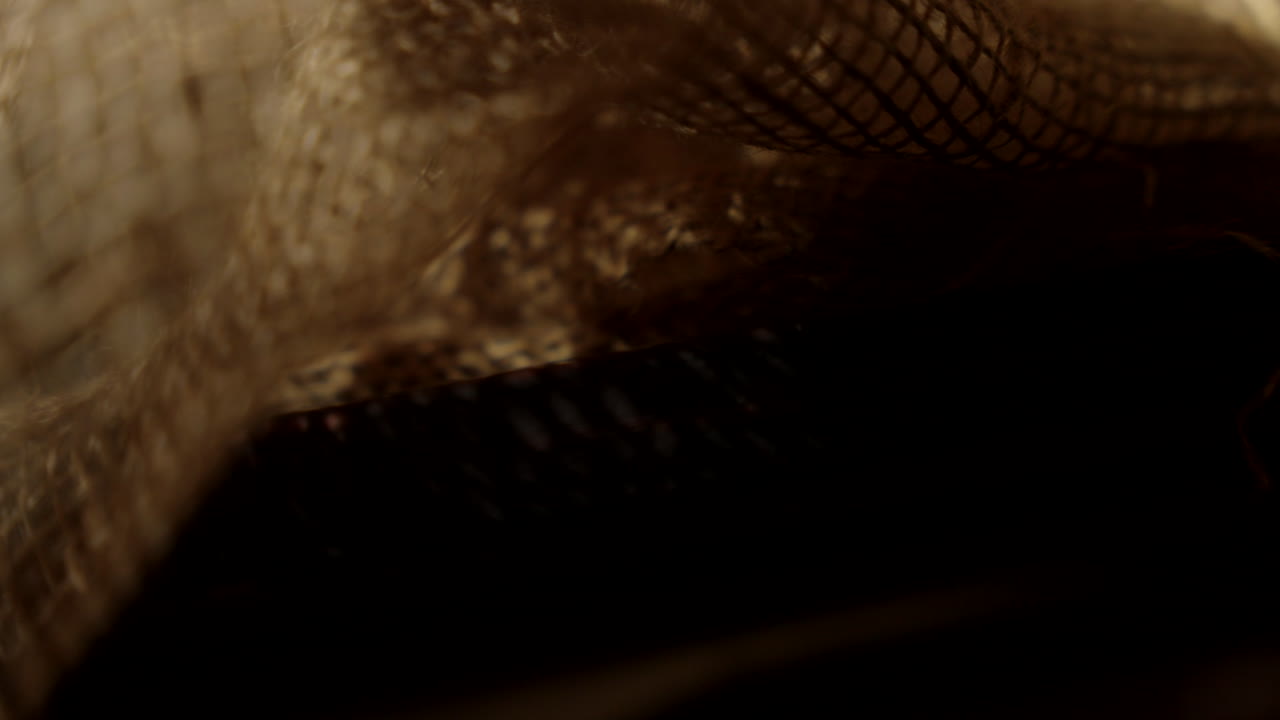 la luz se revela a través de la arpillera en un pesebre de madera