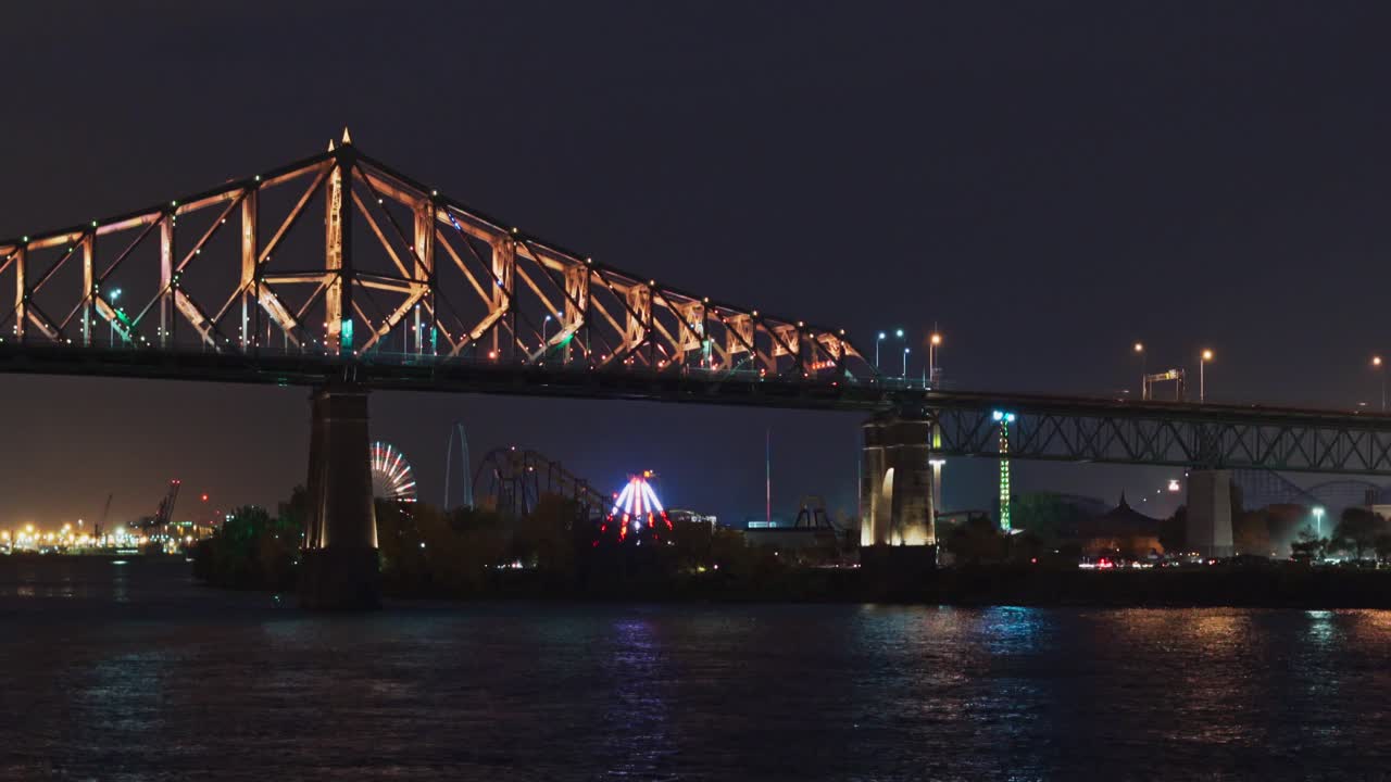 Beautiful view of illuminated Jacques Cartier Bridge from Saint Lawrence River at night, Montreal.