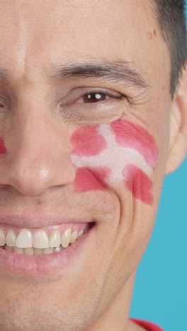man with a danish flag painted on the face smiling