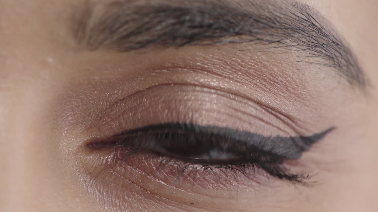 mujer joven abriendo los ojos mirando a la cámara parpadeando usando maquillaje elegante belleza femenina de cerca