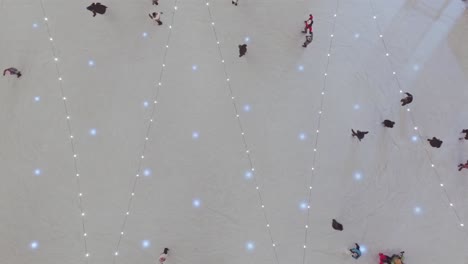 Aerial-descending-over-flashing-lights-and-people-skating-on-ice-rink-in-Zakopane